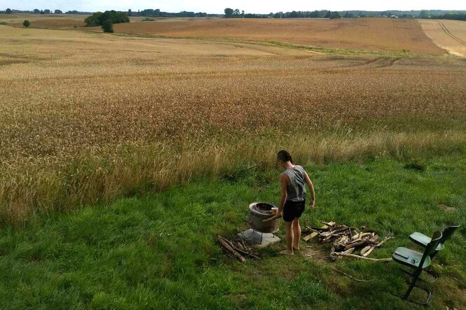 Eine weite Landschaft, im Vordergrund breitet die Autorin ihr Frühstück auf einem Tuch auf dem Boden aus