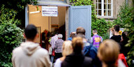 Eine Schlange von Menschen vor dem Eingang eines Berliner Wahllokals