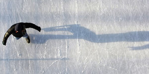 Ein Junge läuft auf einer Eisbahn