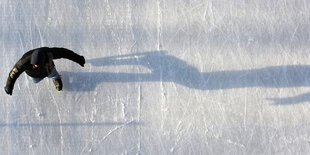 Ein Junge läuft auf einer Eisbahn