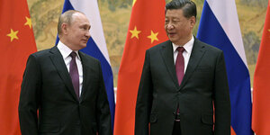 Putin und Xi stehen vor den Flaggen ihrer Länder.