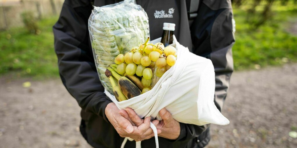 Eine Tüte mit Lebensmitteln. Obenauf Trauben