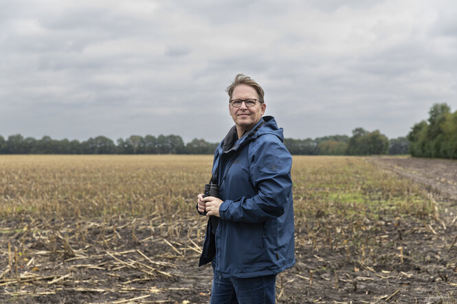 Ein Mann steht in einem abgeernteten Feld