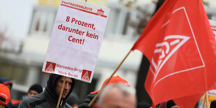 Warnstreikende Menschen schwenken Fahnen vor dem Mercedes-Benz-Werk in Berlin am 17.11.22