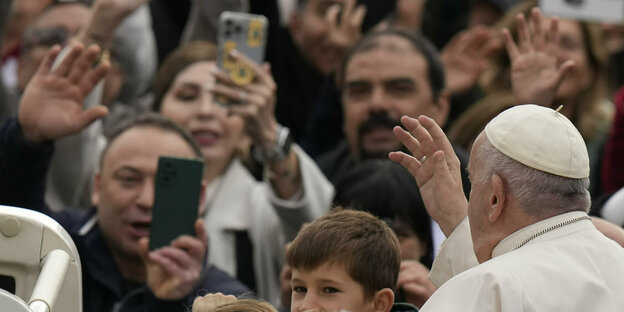 Papst vor winkenden Menschen