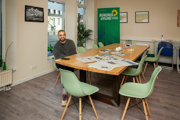 Kassem Taher Saleh sitzt an einem runden Tisch in seinem Wahlkreisbüro