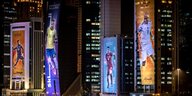 An Hochhäusern im nächtlichen Doha hängen überdimensionale Protraits von Fussballern