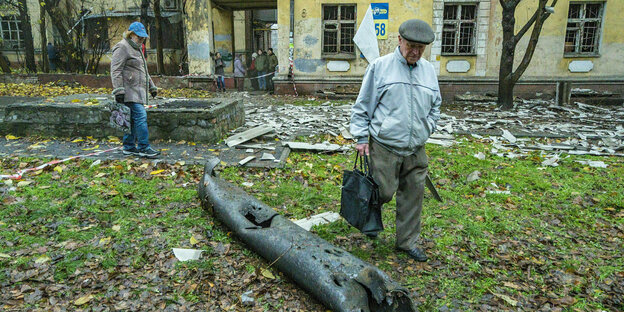 A man looks at the remains of a lamppost