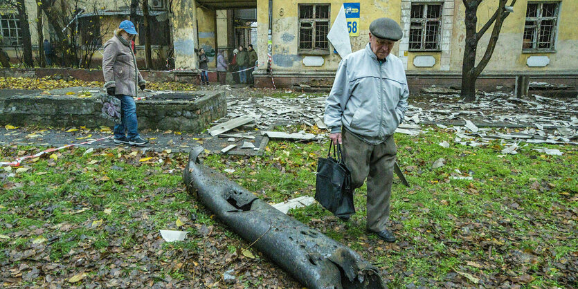 Ein Mann betrachtet die Überreste eines Laternenpfahls