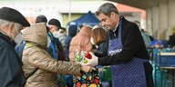 Markus Söder in Schürze verteilt Lebensmittel bei der Münchner Tafel