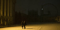 Zwei Menschen laufen durch den Schnee in Kiew