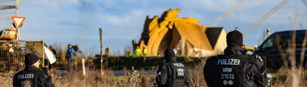 Polizisten stehen in Lützerath am Rande des Braunkohletagebaus.