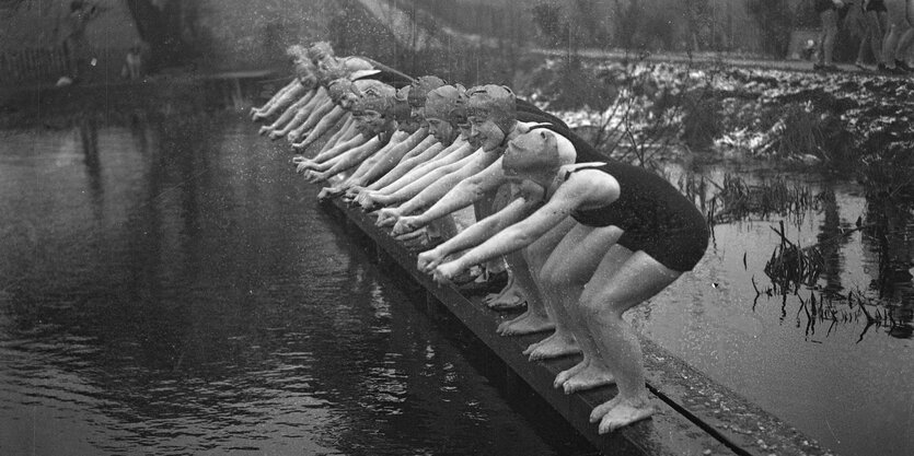 Frauen stehen kurz vor dem Absprung in den See im Park Hampstead Heath im Jahr 1932