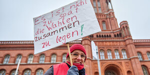 Das Foto zeigt eine Frau, die vor dem Roten Rathaus fordert, den Klima-Volksentscheid mit der Wahl am 12. Februar zusammen zu legen