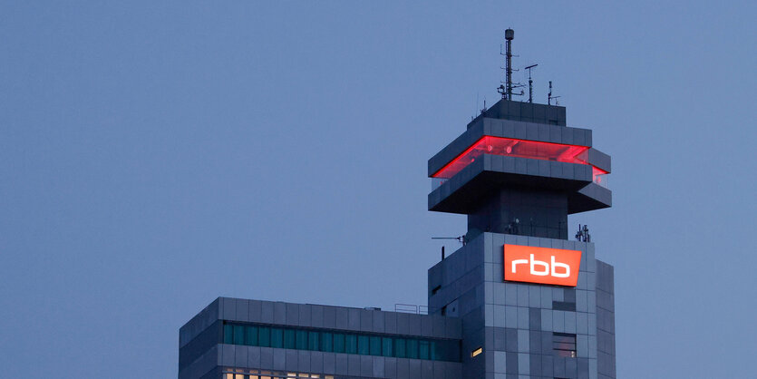 Das beleuchtete Logo des Senders Rundfunk Berlin-Brandenburg (RBB) ist an der Fassade am Sitz des Senders an der Masurenallee angebracht.