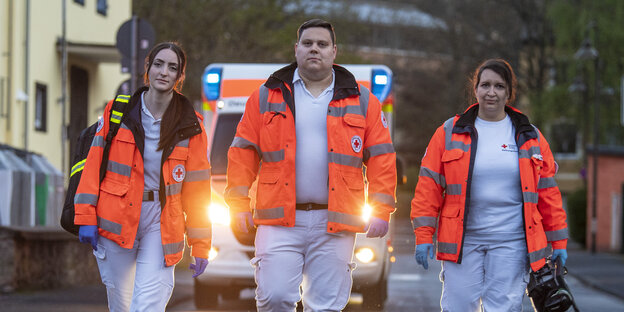Drei Mitarbeiter des Deutschen Rotes Kreuzes gehen auf den Betrachter zu.