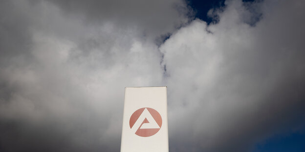 Ein Schild der Bundesagentur für Arbeit vor dramatischen Wolken am Himmel