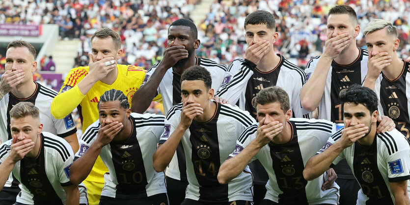 Nationalspieler legen beim Teamfoto eine Hand vor den Mund