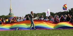 Menschen mit einer riesigen Regenbogenfahne.