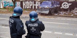 Zwei Polizisten und ein Räumpanzer vor dem Gelände des Köpi-Wagenplatzes in Berlin
