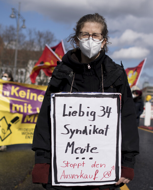 Eine Frau mit umgehängtem Protestplakat Eine Frau mit umgehängtem Protestplakat