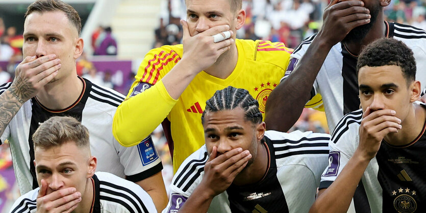 Spieler des DFB-Teams bei der Aufstellung mit Hand vor dem Mund