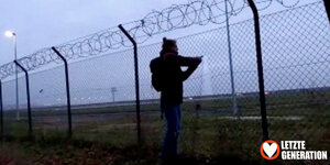 Aktivistin schneidet Zaun am Flughafen BER durch
