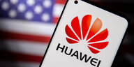 Smartphone mit dem Huawei-Logo vor einer US-Flagge