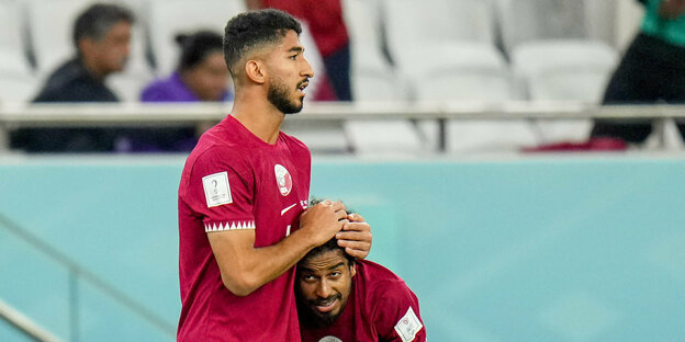Katarischer Spieler legt Mitspieler tröstend Hand auf den Kopf