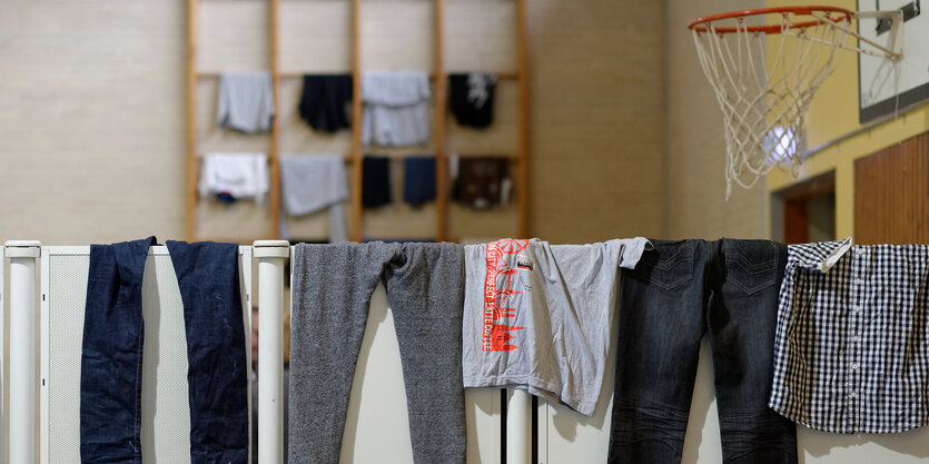 Hosen hängen zum Trocknen in einer zur Flüchtlingsunterkunft umgenutzen Turnhalle im niedersächsichen Roßdorf.