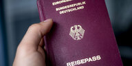 Eine Hand hält einen deutschen Reisepass