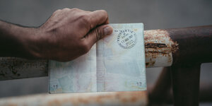 Mann hält afghanischen Pass in den Händen
