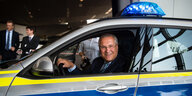 Innenminister Herrmann in einem Polizeifahrzeug