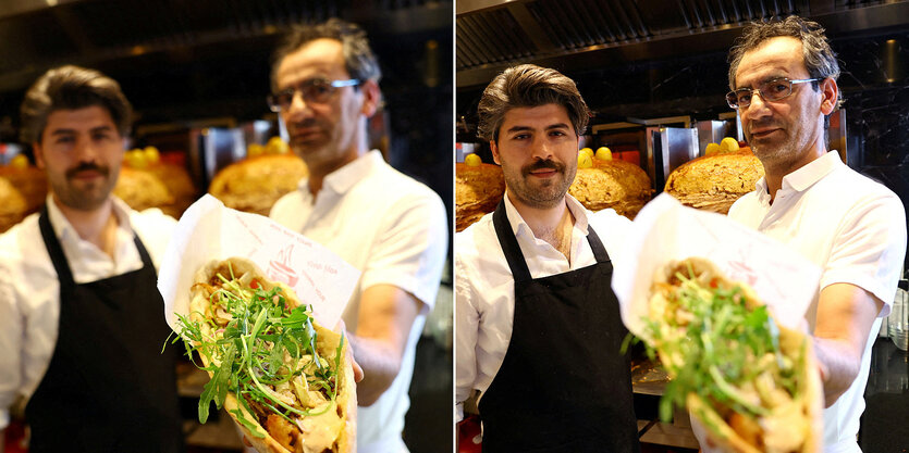 Dönermachende im Portrait, einer hält einen Döner direkt in die Kamera