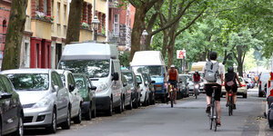 Fahrradfahrende und parkende Pkw auf Wohnstraße