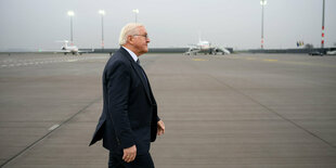 Der Bundespräsident geht über ein Flugfeld, er ist im Profil zu sehen