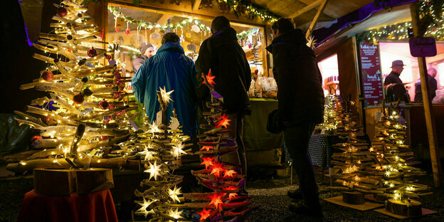 Leute vor einer Bude auf einem Weihnachtsmarkt