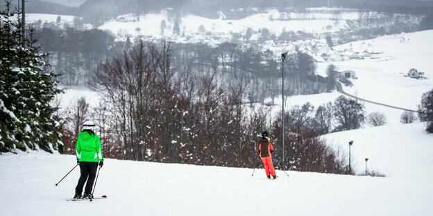 Personen auf Skiern auf einer verschneiten Piste