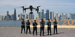Sicherheitskräfte posieren mit einer Drohne