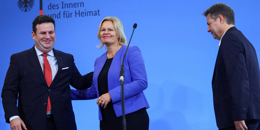 Nancy Faeser, Robert Habeck und Hubertus Heil vor der blauen Wand eines Ministeriums