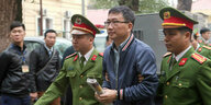 Trinh Xuan Thanh wird von Polizisten geführt.