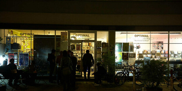 Außenaufnahme von "Schallplatten Optimal" in München Dunkeln, drinnen brennt Licht.
