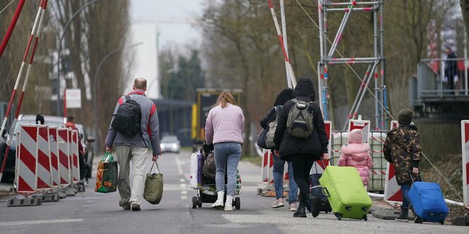 Menschen mit Koffern laufen auf einer Straße