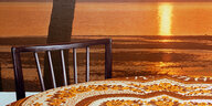 Das in Bad Salzuflen entstandene Bild wirft einen Blick auf einen Tisch mit Dekostoff-Tischdecke, einem neobarocken Pressholzstuhl und im Hintergrund dem Reflex einer untergehenden Sonne auf einer Wasserfläche.