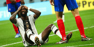 Verteidiger Antonio Rüdiger sitzt auf dem Fußballfeld und schlägt entsetzt die Hände über dem Kopf zusammen