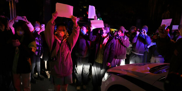 Menschen mit weißen Papierblättern protestieren
