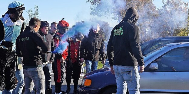 Aktivisten mit Rauchbomben blockieren eine Straße