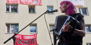 Mensch mit bunten Haaren spielt Akkordeon in der Habersaathstraße