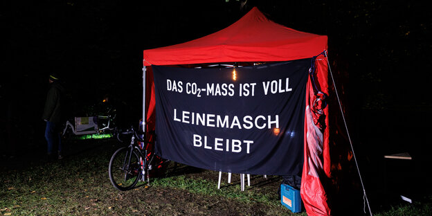 Ein rotes Zelt mit einem Protestbanner auf dem steht "Das CO2-Maß ist voll - Leinemach bleibt" steht in einem von Rodungen bedrohten Naherholungsgebiet bei Hannover