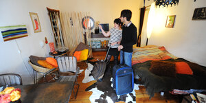 2 Menschen mit ROllkoffer in einer Airbnb-Wohnung
